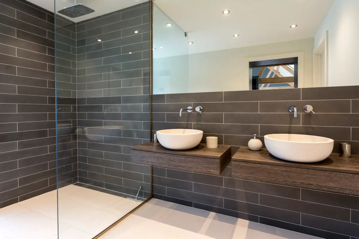 Remodeled bathroom with gray tile and a glass shower in a Massachusetts home