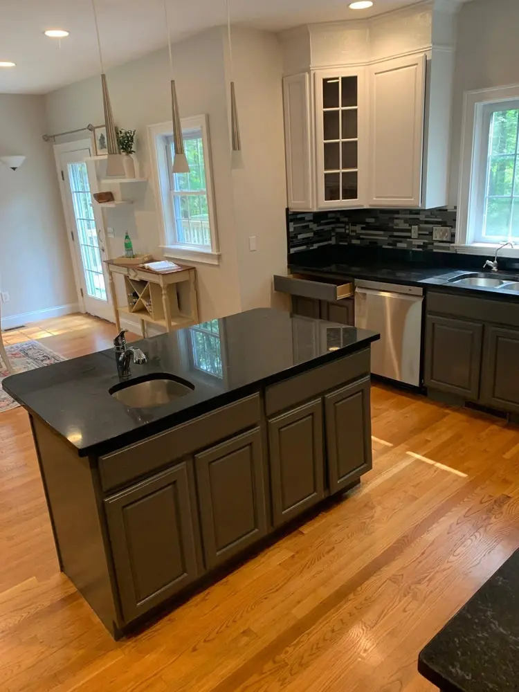 Remodeled kitchen with gray cabinets and dark granite counters in a Massachusetts home